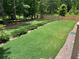 A spacious backyard featuring a manicured lawn, newly installed fence, and landscape lighting at 5745 Pickens Garden Ln, Powder Springs, GA 30127