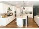 Bright kitchen features white cabinets, stainless appliances, large island with counter seating, and hardwood flooring at 5745 Pickens Garden Ln, Powder Springs, GA 30127