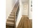 Staircase featuring carpeted steps, wooden handrail, and modern black iron balusters at 5745 Pickens Garden Ln, Powder Springs, GA 30127
