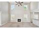 Spacious living room with a high ceiling, ceiling fan, fireplace, and large windows allowing ample natural light at 2373 Shady Maple Ln, Loganville, GA 30052