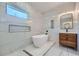 Modern bathroom featuring a freestanding tub, sleek vanity, and stylish tile accents, flooded with natural light at 548 Fletcher St, Atlanta, GA 30310