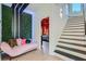 Stylish hallway with a unique green wall feature, a pink sofa, and a staircase leading to the upper levels at 548 Fletcher St, Atlanta, GA 30310