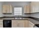 Well-lit kitchen featuring stone countertops and a double stainless steel sink under a window at 73 Atlanta Sw Ave, Atlanta, GA 30315