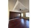 Spacious bedroom featuring a tray ceiling, ceiling fan and hardwood floors at 7563 Avalon Blvd # 305, Fairburn, GA 30213
