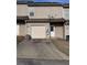 View of garage with driveway and back exterior of home at 7563 Avalon Blvd # 305, Fairburn, GA 30213