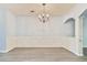 Elegant dining room with wainscoting, a modern chandelier, and wood-look floors for sophisticated dining at 1526 Viero Dr, Lawrenceville, GA 30044