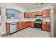 Well-lit kitchen with stainless steel appliances, warm wood cabinets, and wood-look floors, perfect for cooking at 1526 Viero Dr, Lawrenceville, GA 30044