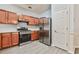 Modern kitchen featuring stainless steel appliances, wood cabinets, and wood-look floors, a chef's delight at 1526 Viero Dr, Lawrenceville, GA 30044