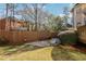 Fenced backyard with stone patio, manicured lawn, mature trees, and play area at 1056 Shady Valley Ne Pl, Brookhaven, GA 30324