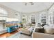 Bright living room featuring a sectional sofa, arched windows, and a stylish blue media cabinet at 1056 Shady Valley Ne Pl, Brookhaven, GA 30324