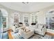 A spacious living room showcases a large sectional sofa, ottoman, and natural light from arched windows at 1056 Shady Valley Ne Pl, Brookhaven, GA 30324