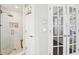 Large walk-in shower features glass doors, white tile walls, and a built-in shower caddy at 1056 Shady Valley Ne Pl, Brookhaven, GA 30324