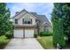 Charming two-story home features a brick facade, two-car garage, and well-manicured landscaping at 1909 Sawgrass Dr, Hampton, GA 30228