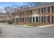 A brick townhouse with black shutters, trimmed windows, and well manicured landscaping at 1101 Collier Nw Rd # V3, Atlanta, GA 30318