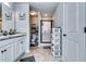 Bathroom featuring double sinks, a shower with glass door, and storage shelves at 1709 Creel Ln, Atlanta, GA 30349