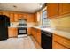 Well-lit kitchen featuring wooden cabinets, black appliances, and durable tile flooring at 2410 Deep Shoals Cir, Decatur, GA 30034