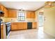 Traditional kitchen with wooden cabinets, tile floors, a window overlooking the yard and black appliances at 2410 Deep Shoals Cir, Decatur, GA 30034