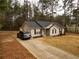 A well-maintained home showcases a cozy exterior, lush pine trees, a gray SUV, and a lengthy concrete driveway at 284 Southern Trace Way, Rockmart, GA 30153