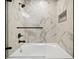 Close-up of a modern tub-shower combo with sleek fixtures and elegant marble-patterned tile surround at 3445 Stratford Ne Rd # 2504, Atlanta, GA 30326