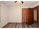 This bedroom features gray vinyl flooring and a dark-stained wood, louvered door for the closet at 4800 Timber Ridge Dr, Douglasville, GA 30135