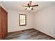 This bedroom features gray vinyl flooring and a dark-stained wood, louvered door for the closet at 4800 Timber Ridge Dr, Douglasville, GA 30135