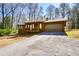 Exterior view of single-story home showing the attached garage and long driveway, with mature trees at 4800 Timber Ridge Dr, Douglasville, GA 30135