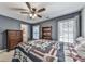 Comfortable bedroom featuring a patriotic quilt, ceiling fan, wood bookcase and lots of natural light from two windows at 1009 Fairway Seven, Villa Rica, GA 30180