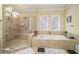 Bathroom features a walk-in shower, soaking tub and decorative glass windows, creating a luxurious spa experience at 6016 Southland Dr, Stone Mountain, GA 30087