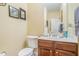 A half bathroom features wood cabinetry with a sink, a mirror and a standard toilet at 6016 Southland Dr, Stone Mountain, GA 30087