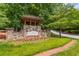 A stone entrance to Great Sky welcomes visitors with meticulous landscaping, framed by a charming stone structure at 216 Crescent Moon Way, Canton, GA 30114