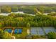 Aerial view showing four well-maintained tennis courts by the lake and surrounded by mature trees at 216 Crescent Moon Way, Canton, GA 30114