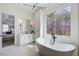 Modern bathroom with free-standing tub, vanity, and a large window with a wooded view at 555 Lower Birmingham Rd, Canton, GA 30115