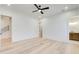 Spacious bedroom with light wood floors, ceiling fan, white trim, and staircase access at 555 Lower Birmingham Rd, Canton, GA 30115