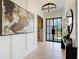 Light-filled foyer with chandelier, wall art, bench and black framed door at 555 Lower Birmingham Rd, Canton, GA 30115