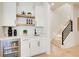 Stylish wet bar boasts sleek cabinetry, beverage fridge, open shelving, and nearby stairs at 555 Lower Birmingham Rd, Canton, GA 30115