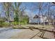 The home features a spacious backyard, concrete driveway, lush greenery, metal fence and mature trees at 1627 Walker Ave, College Park, GA 30337