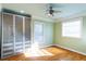 Light-filled bedroom featuring green walls, hardwood floors, ceiling fan and frosted glass door closet at 1627 Walker Ave, College Park, GA 30337