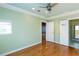 Bright bedroom features green walls, hardwood floors, ceiling fan, and multiple doorways at 1627 Walker Ave, College Park, GA 30337