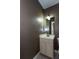 Half bathroom includes a single sink vanity, large mirror, modern lighting and tiled floor at 1627 Walker Ave, College Park, GA 30337