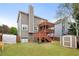Landscaped backyard featuring a spacious deck, a lush lawn, and mature trees create a serene outdoor retreat at 2605 Jacobean Rd, Acworth, GA 30101