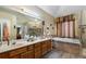 Spacious bathroom featuring dual sinks, a soaking tub, and a separate glass-enclosed shower at 2605 Jacobean Rd, Acworth, GA 30101
