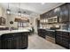 Bright eat-in kitchen with dark cabinetry, stainless appliances, granite counters, and modern pendant lighting at 2605 Jacobean Rd, Acworth, GA 30101