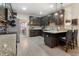 Well-lit kitchen features an island with seating, stainless steel appliances, dark cabinets, and granite countertops at 2605 Jacobean Rd, Acworth, GA 30101