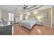 Bright bedroom features a trey ceiling, hardwood floors, a ceiling fan, and shuttered windows at 4073 Hickory Fairway Dr, Woodstock, GA 30188