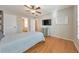 Comfortable bedroom featuring hardwood floors, a ceiling fan, and a mounted television at 4073 Hickory Fairway Dr, Woodstock, GA 30188