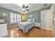 Charming bedroom with hardwood floors, ceiling fan, and ample natural light from window with plantation shutters at 4073 Hickory Fairway Dr, Woodstock, GA 30188