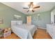 Inviting bedroom featuring light green walls, hardwood floors, a ceiling fan, and abundant natural light at 4073 Hickory Fairway Dr, Woodstock, GA 30188