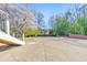 Expansive driveway with surrounding trees and partial brick perimeter wall, perfect for guest parking at 4073 Hickory Fairway Dr, Woodstock, GA 30188
