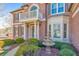 Close up view of front entrance with fountain, manicured shrubs, and a small balcony above the doorway at 4073 Hickory Fairway Dr, Woodstock, GA 30188