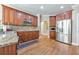 Open kitchen with granite counters, wood cabinets, wood floors, and stainless steel appliances at 4073 Hickory Fairway Dr, Woodstock, GA 30188